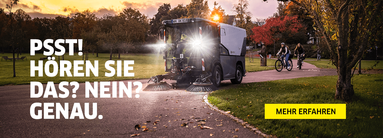 MC 250 Electric Das Bild zeigt eine leise Kehrmaschine bei Sonnenuntergang in einem Park. Während die Maschine kehrt, fahren im Hintergrund ungestört Radfahrer vorbei. Der groß geschriebene Text "PSST! HÖREN SIE DAS? NEIN? GENAU." und der gelbe Button "MEHR ERFAHREN" bet