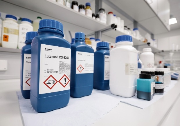 Eine Nahaufnahme einer blauen Flasche BASF Lutensol CS 6250 mit deutlichen GHS-Gefahrenpiktogrammen (Ätzwirkung und Warnhinweis).