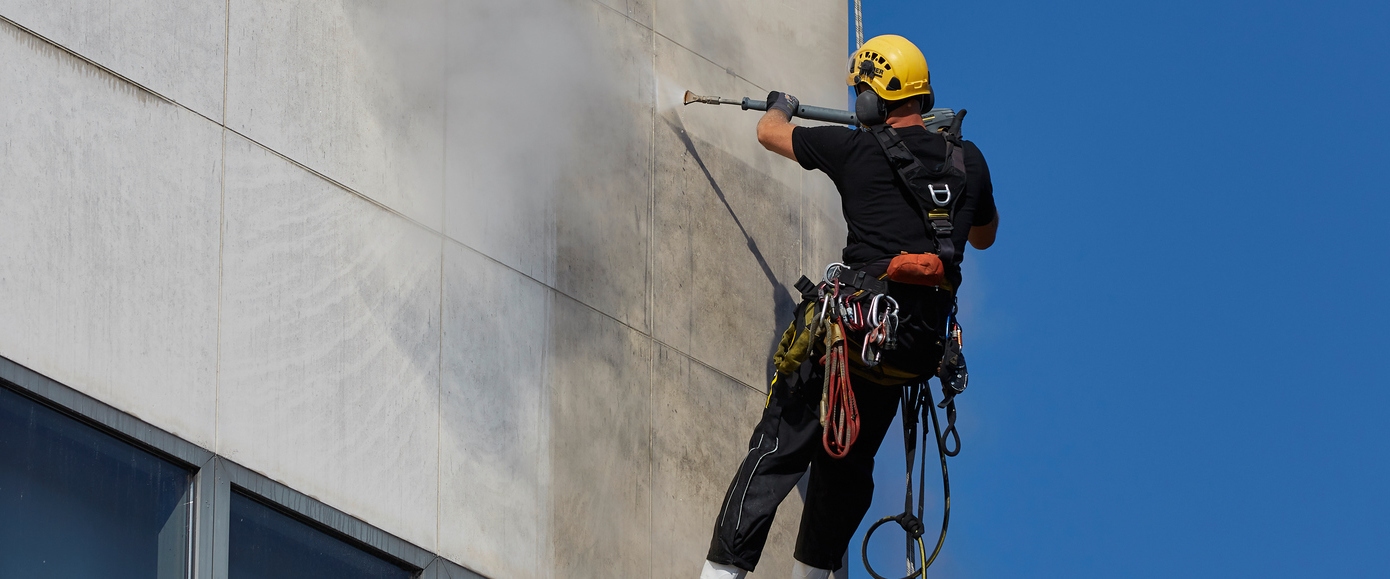 Mann reinigt Fassade