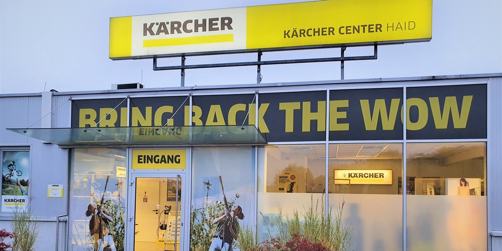 Frontansicht des Kärcher Centers Haid mit dem markanten Slogan „BRING BACK THE WOW“ über dem Eingangsbereich