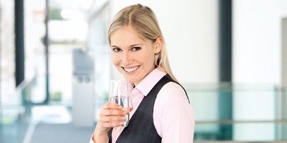 Kärcher Wasserspender Filterpakete Eine lächelnde Frau genießt ein Glas frisches Wasser aus einem Kärcher Wasserspender. Individuell zusammenstellbare Filterpakete wie Active-Pure, Hy-Protect, Hy-Pure oder UV-Protect garantieren eine wirksame Filterung.