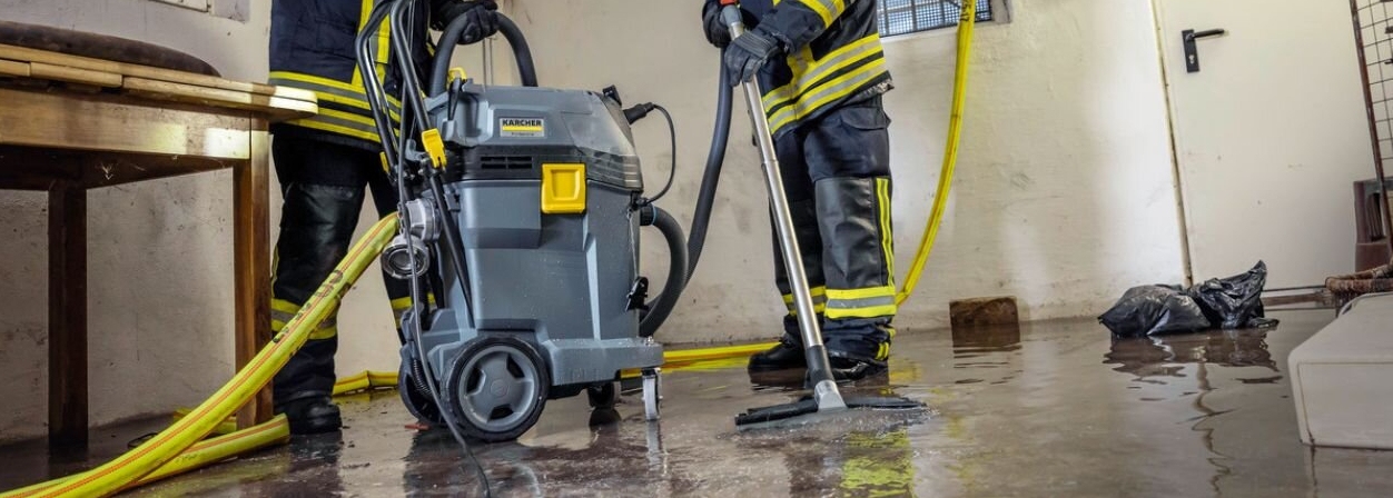 Brandweer gebruikt waterzuiger Brandweermannen gebruiken een waterzuiger om een kelder leeg te zuigen