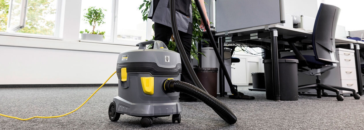 stofzuiger-bureau Persoon maakt kantoor schoon met een stofzuiger