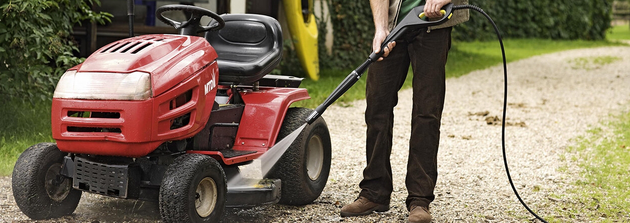 Verbrandingsmotor hogedrukreiniger Persoon maakt tractor schoon met hogedrukreiniger