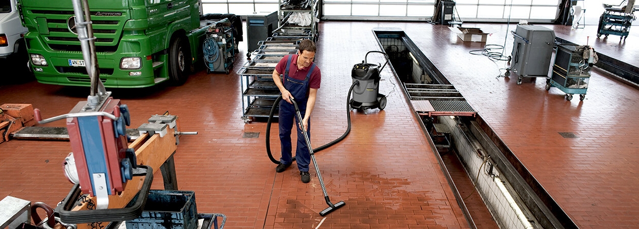 Water-en stofzuiger Standaard-klasse Man stofzuigt garage met water- en stofzuiger
