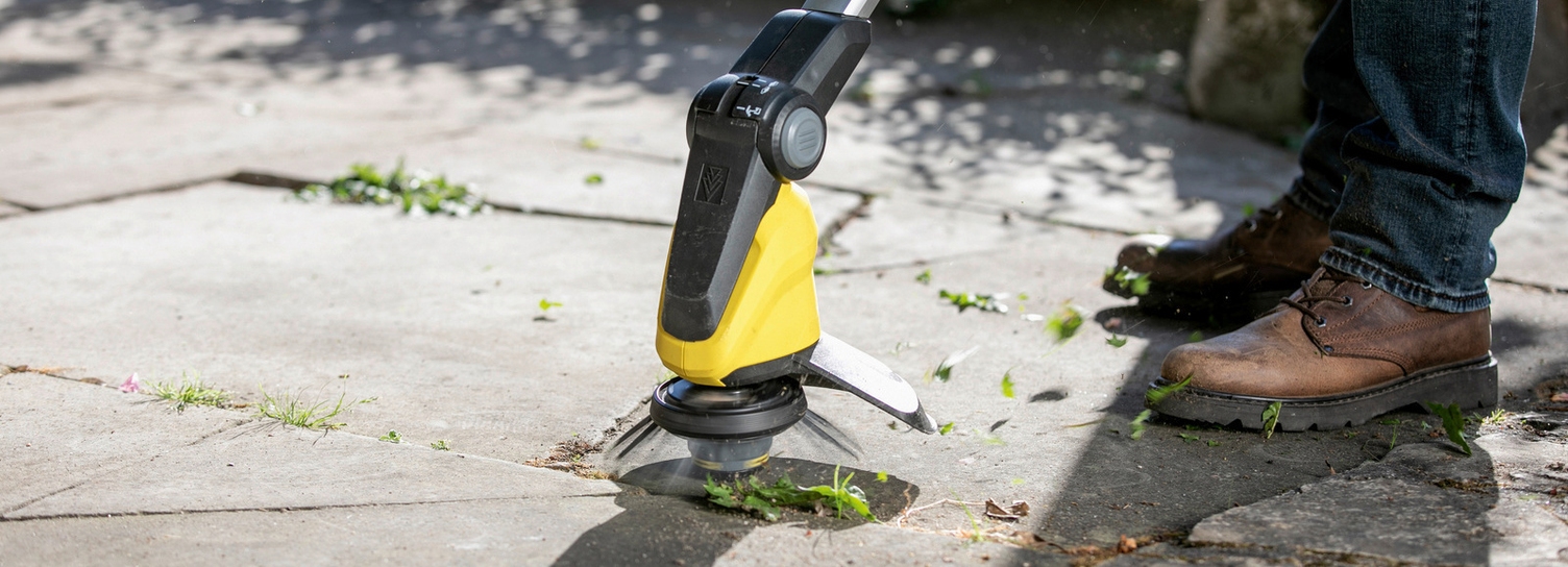 Terrassen schoonmaken met een draadloze onkruidverwijderaar Kärcher: man reinigt terrastegels met een draadloze onkruidverwijderaar