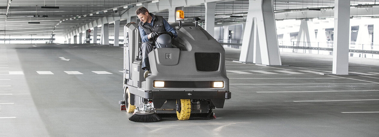 Zit schrob-zuigmachine op een grote parkeerplaats Zit schrob-zuigmachine op een grote parkeerplaats