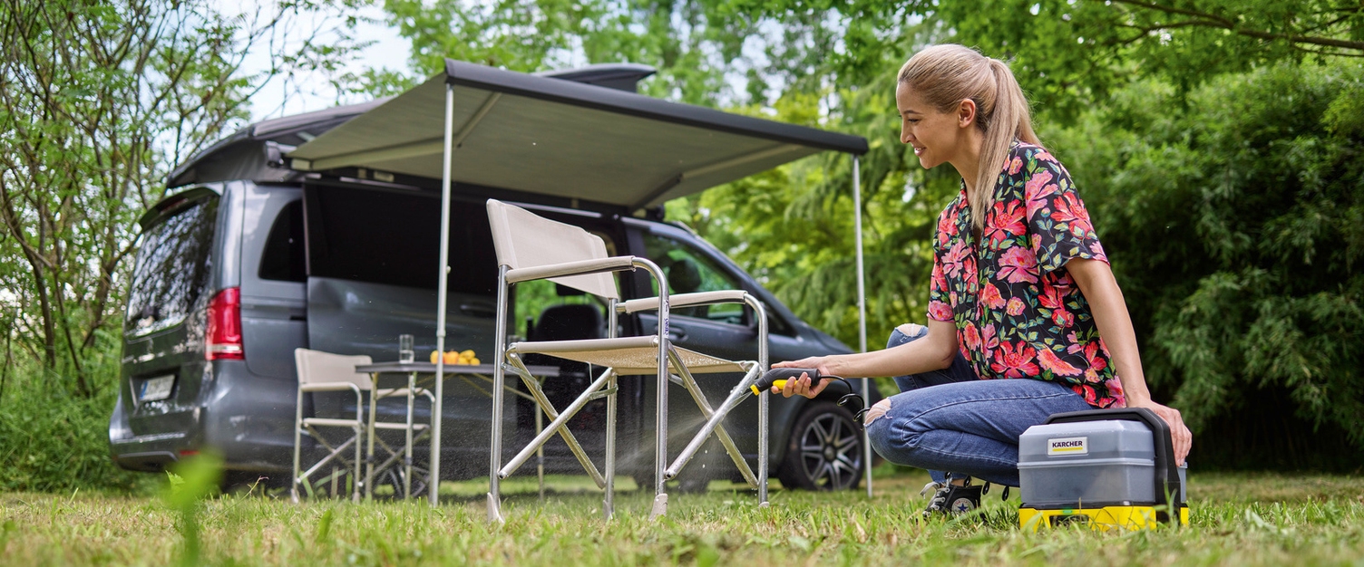 Vrouw reinigt haar campingstoel met een Kärcher OC 3