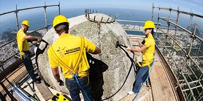 Grondige behandeling van de bovenzijde van het beeld tegen weersinvloeden Technici werken op de top van het hoofd van Cristo Redentor met uitzicht over de baai.