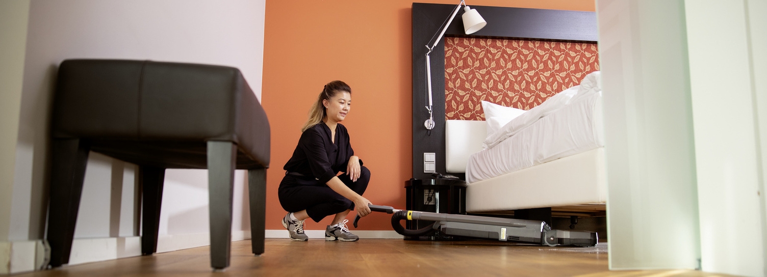 Een Kärcher CV 30/2 Bp professionele stofzuiger reinigt onder een bed
