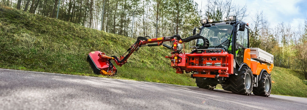 gemeente werktuigdragers Een gemeente werktuigdrager snoeit een berm langs de weg