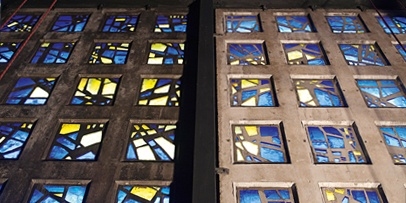 Voor-en-na vergelijking van de donkere, vervuilde wand en het lichte, gereinigde betonoppervlak van de kerk.