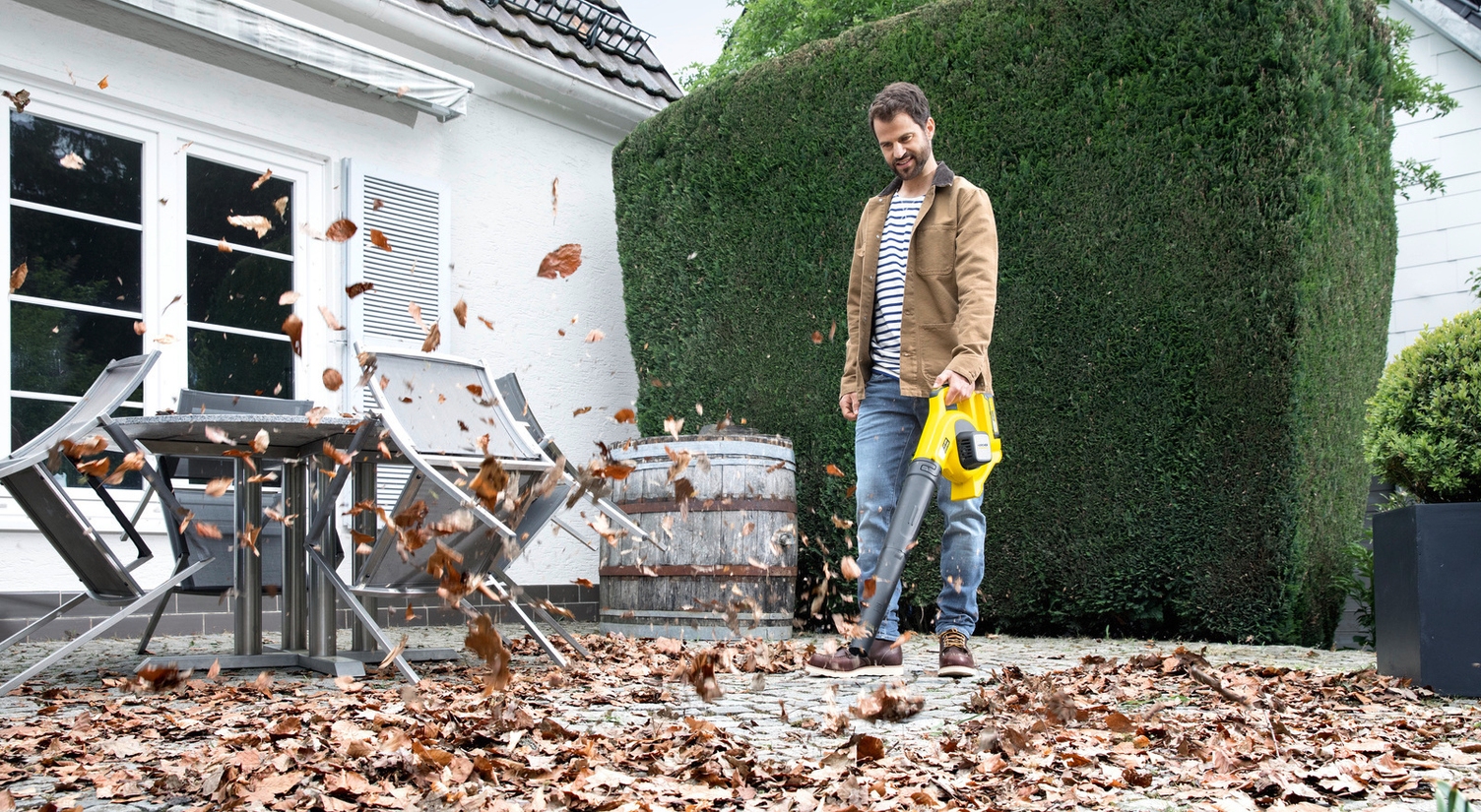 Clearing leaves in autumn with a leaf blower