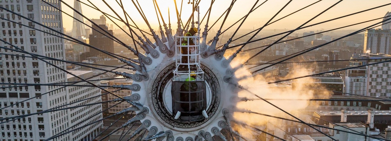 Grondige reiniging van de asophangingen bij de 70 meter hoge naaf van het reuzenrad Kärcher-reinigingsspecialisten in een werkbak op 70 meter hoogte bij de naaf van de London Eye.