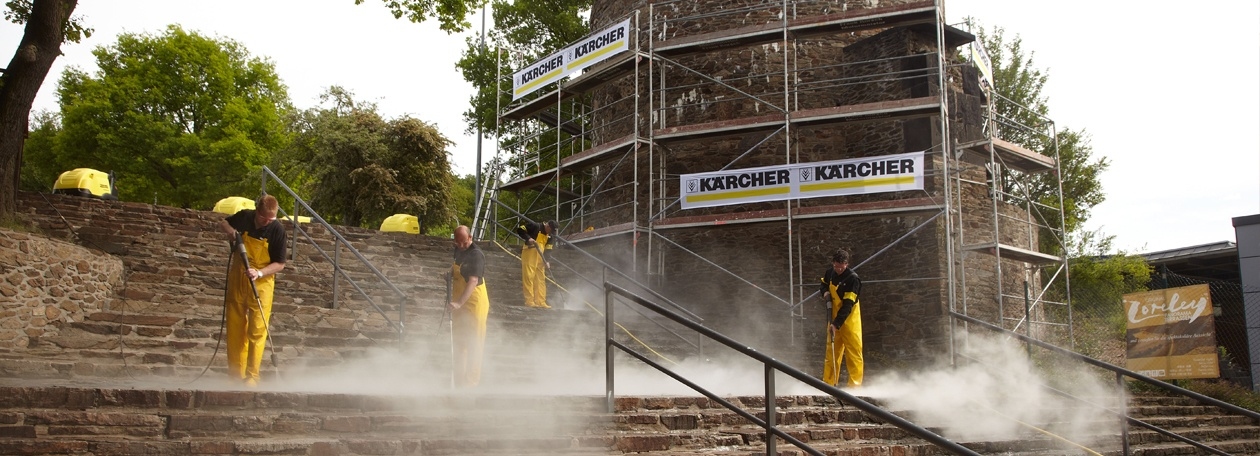 Grondige reiniging van de stenen trappen en toeschouwerplaatsen met 95 °C heet water onder hoge druk Kärcher-technici reinigen de stenen trappen van het openluchttheater Loreley met warmwater-hogedrukreinigers.