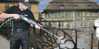 Een Kärcher-specialist reinigt de gietijzeren balustrade van de Brug van de Leugenaars in Sibiu.