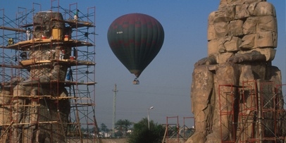 Opbouw van steigers voor de conserverings- en reinigingsmaatregelen van Kärcher Steigers opgesteld rond de meer dan 14 meter hoge Memnonkolossen tijdens restauratiewerkzaamheden met een heteluchtballon in de lucht.