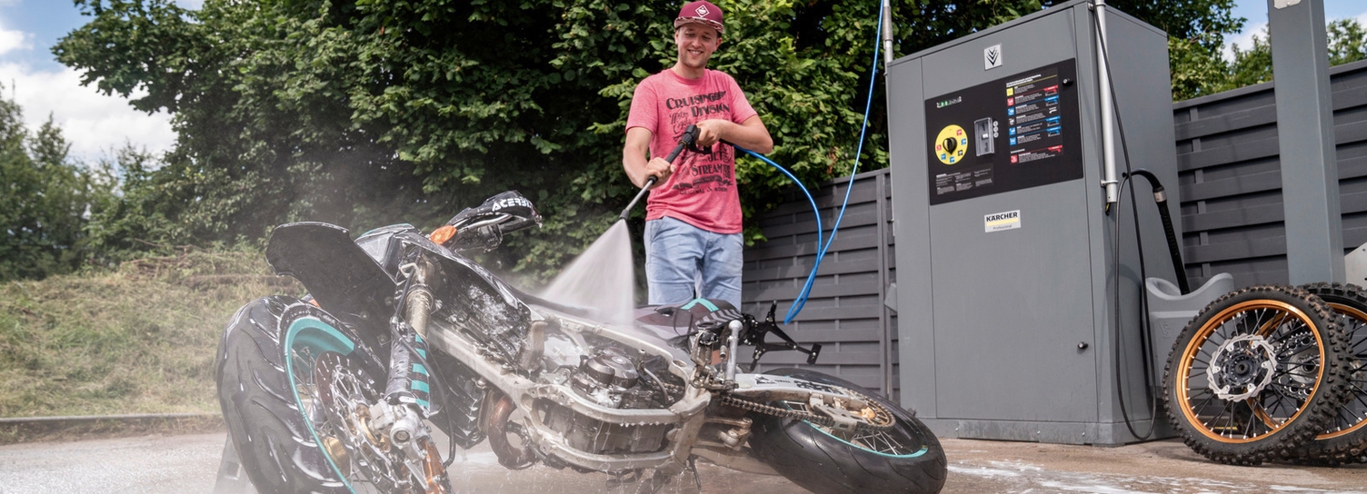 Een motor schoonmaken op een wasplaats Een man reinigt zijn motor op een wasplaats van Kärcher