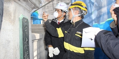 Nauwkeurige inspectie van de scheuren en vervuiling van het graniet vóór de reiniging Kärcher-technici inspecteren de staat van de granieten pijlers en de opgeschroefde platen van de brug.