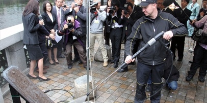 Schoonmaken van de zone rond de bronzen plaat die het kilometers-nulpunt van Japan markeert en Kärcher-technicus reinigt zorgvuldig de bestrating rond het historische nulpunt op de Nihonbashi-brug.