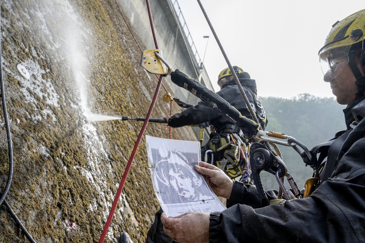 Persevent ter gelegenheid van de creatie van een reverse graffiti kunstwerk op damwand in Vianden