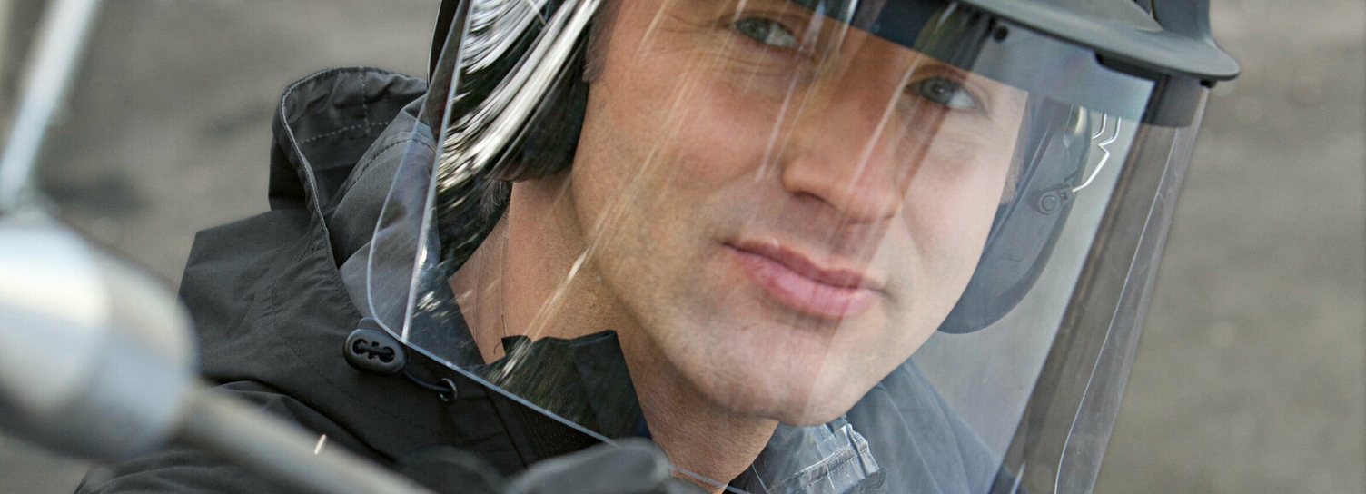 Een persoon draagt een Kärcher helm met gezichtsbescherming