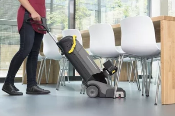 Stofzuigen-onder-stoelen Persoon stofzuigt onder stoelen