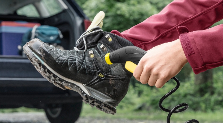 Vrouw reinigt haar wandelschoenen met een Kärcher OC 3