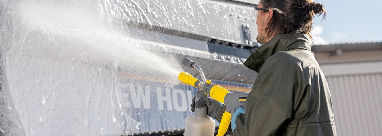 Persoon gebruikt hogedrukreiniger met detergent om schoon te maken