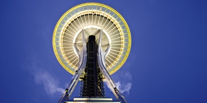 Het iconische resultaat van het Duits-Amerikaanse Kärcher-reinigingsproject Symmetrisch zicht van onderaf op het ronde, verlichte platform en de stalen benen van de Space Needle.