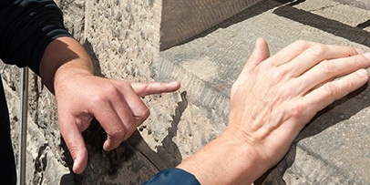 Restaurateur en Kärcher-expert beoordelen de staat van de historische natuursteen met de hand.