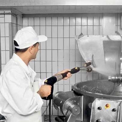 Medewerker spuit een industriële mengbak schoon met behulp van een Kärcher lans voor hygiënische reiniging