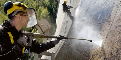 Industriële klimmers werken het dynamische vissenmotief uit Een industriële klimmer van Kärcher spuit geconcentreerd de contouren van het kunstwerk schoon op het beton.