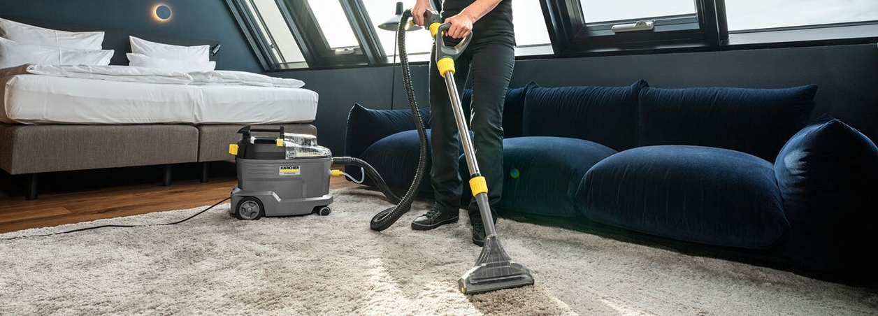 Persoon reinigt tapijt in een slaapkamer