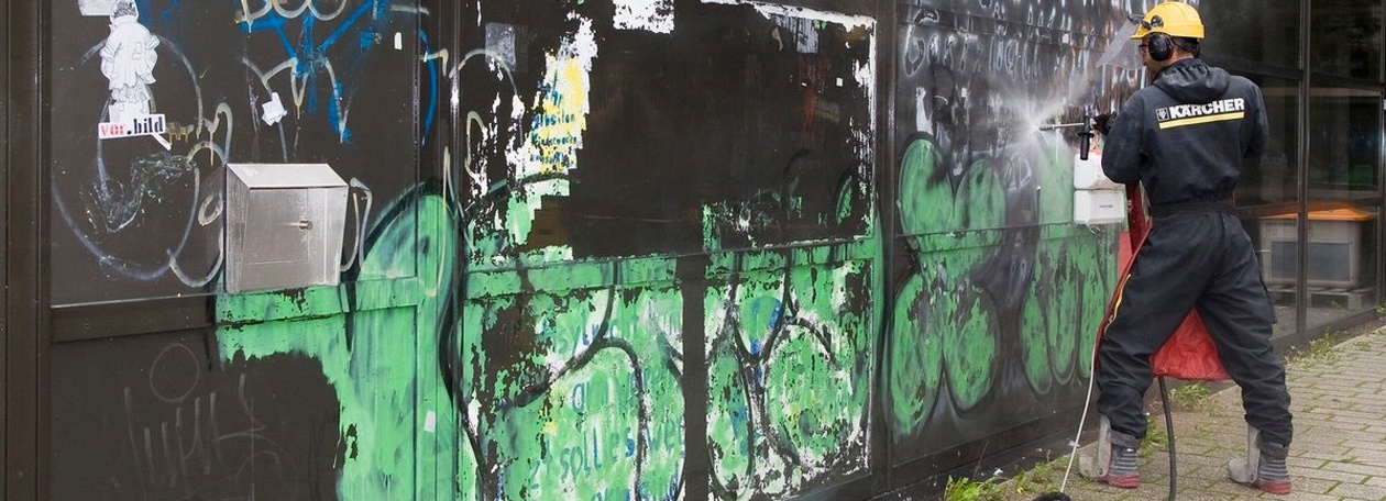 Materiaalvriendelijke graffitiverwijdering met droogijsstralen van de geanodiseerde aluminium gevel Een Kärcher-technicus verwijdert graffiti van de aluminium gevel van het Brecht-Bau van de universiteit van Tübingen.