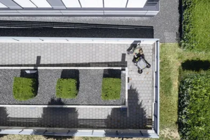 Persoon gebruikt veegmachine om zijn tuin schoon te maken