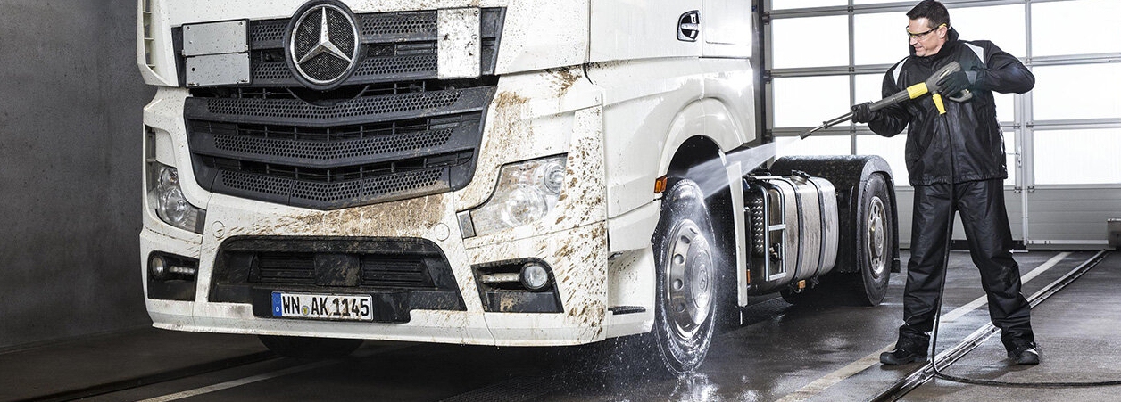 Man maakt witte vrachtwagen terug proper met hogedrukreiniger