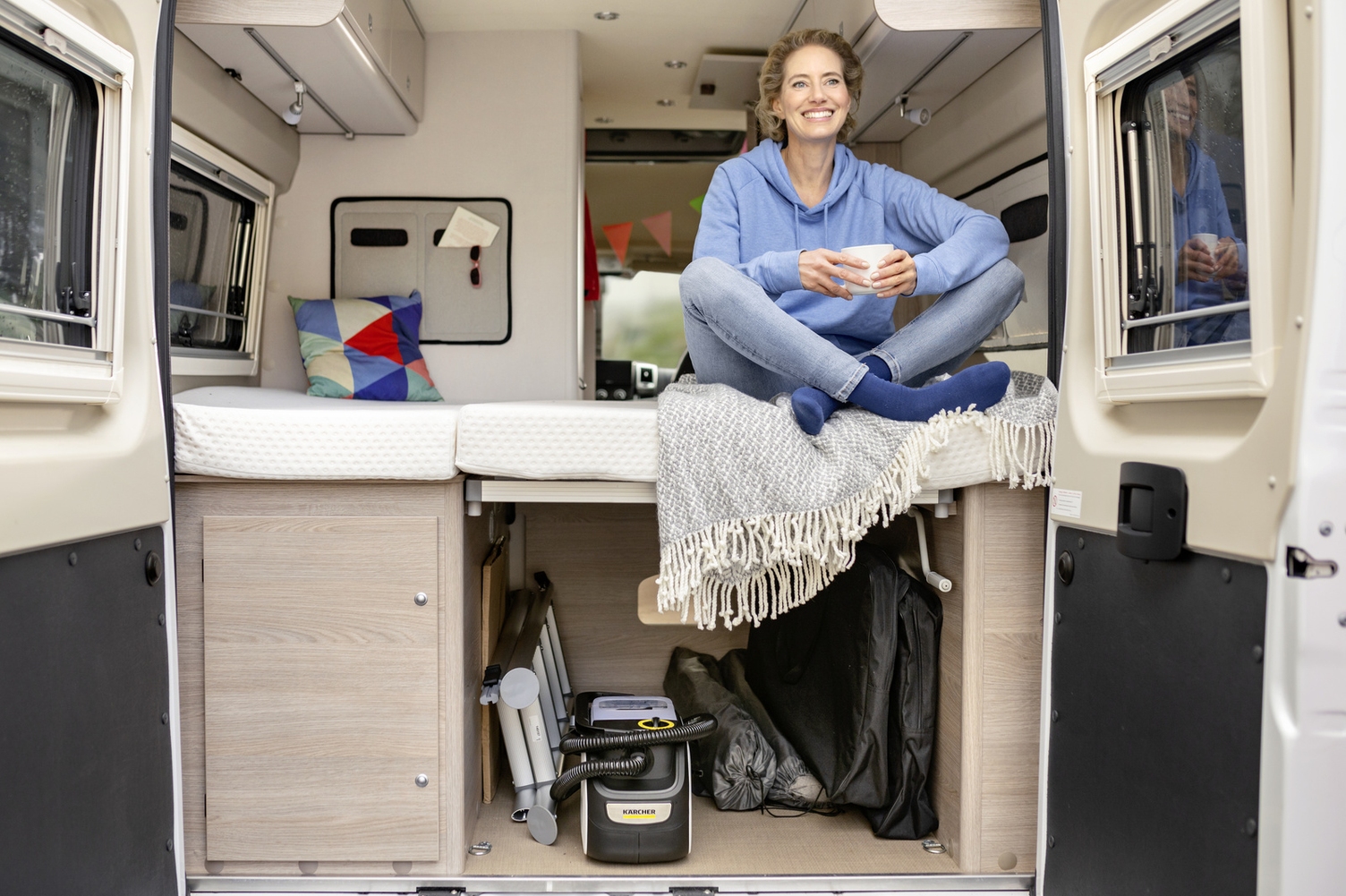 Man maakt de kussens van zijn camper schoon met een stofzuiger van Kärcher