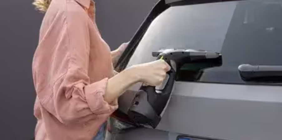 Achterruit auto schoonmaken Window Vac Vrouw gebruikt een Window Vac om de achterruit van een auto schoon te maken