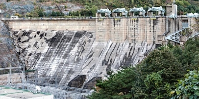 Zijaanzicht van de 98 meter hoge Chungju-stuwdam waarop het tijgermotief door het contrast steeds duidelijker wordt.