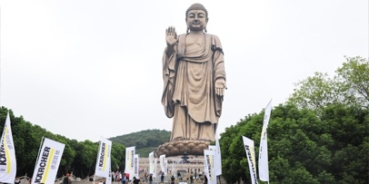 Kärcher-vlaggen markeren het reinigingsproject bij het Lingshan-monument De Grote Boeddha van Lingshan met Kärcher-vlaggen op de voorgrond.