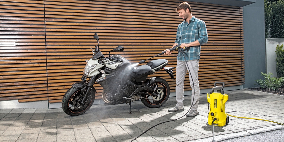Je motor wassen Man reinigt motor met hogedrukreiniger