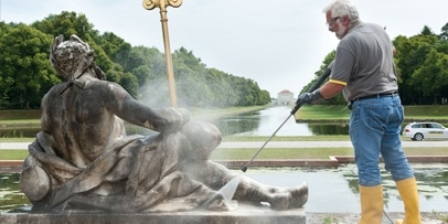 Veilige stoomreiniging van de historische marmeren figuren Isar en Donau Een restaurateur reinigt een van de marmeren beelden bij de cascade in Schlosspark Nymphenburg.
