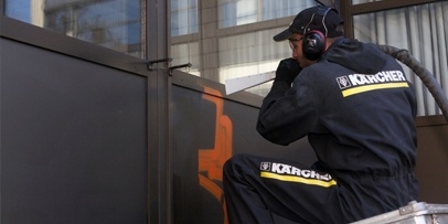 Nauwkeurige graffitiverwijdering met het IB 15/80 droogijsstraalapparaat op aluminium panelen Een Kärcher-technicus reinigt geanodiseerde aluminium gevelpanelen met een droogijsstraalpistool.