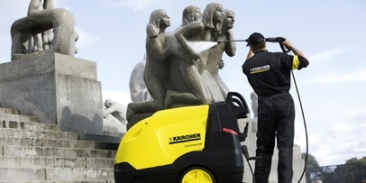 Een Kärcher-medewerker reinigt een van de granieten mensfiguren in het Vigelandpark met een warmwater-hogedrukreiniger.