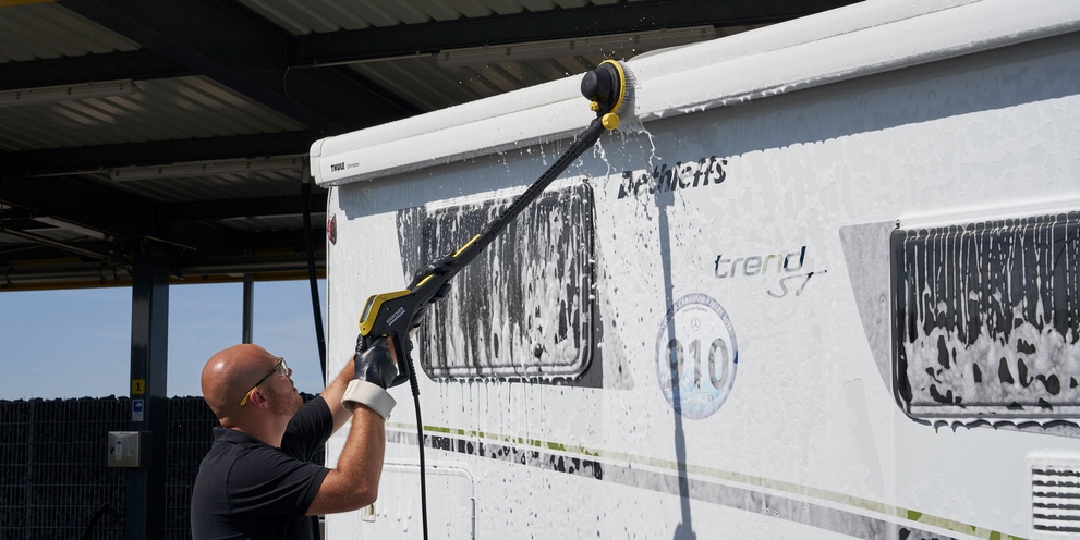 Man maakt zijn camper schoon met een reinigingsmiddel van Kärcher