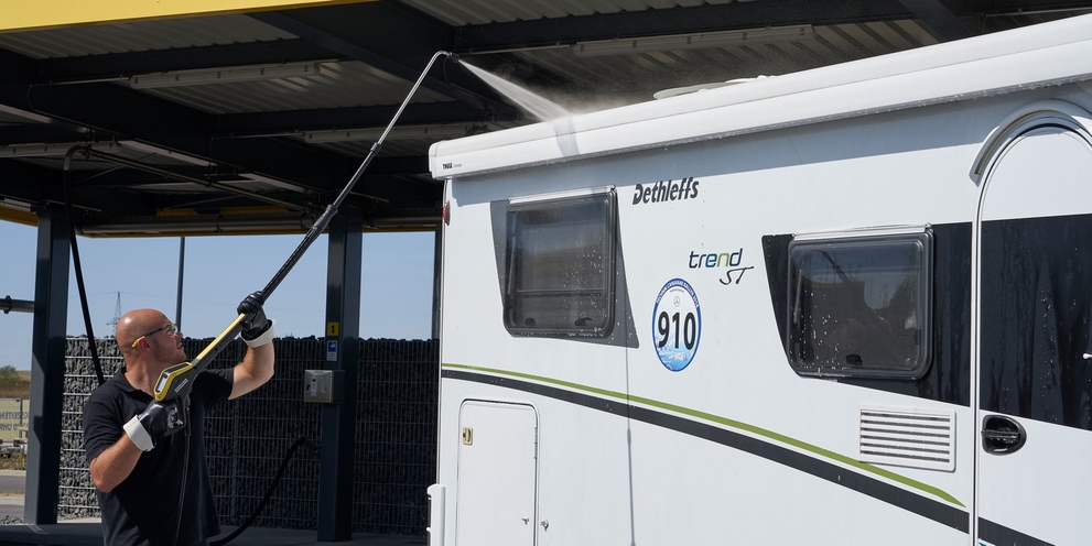 Man gebruikt een telescopische lans van Kärcher om het dak van zijn camper schoon te maken