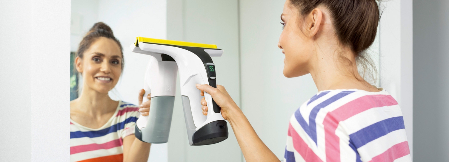 Femme nettoyant un miroir avec l'aspirateur nettoyeur de vitres Kärcher
