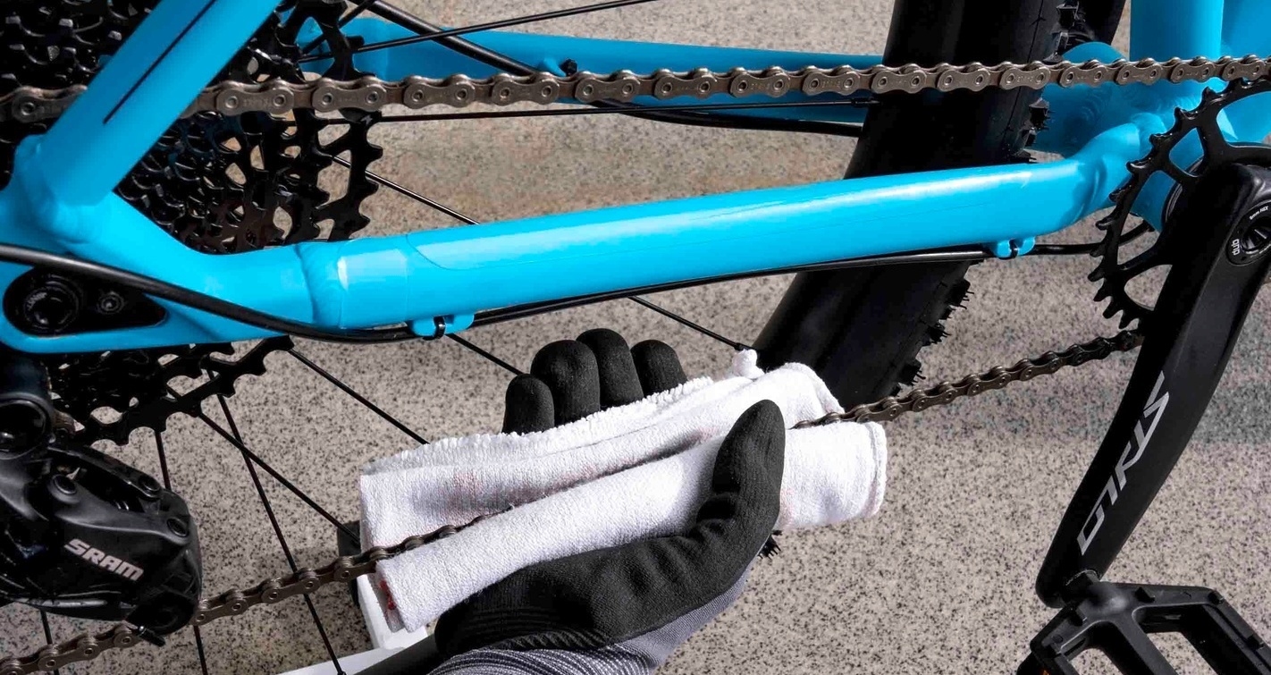 Fahrradkette wird mit mit einem Tuch gereinigt