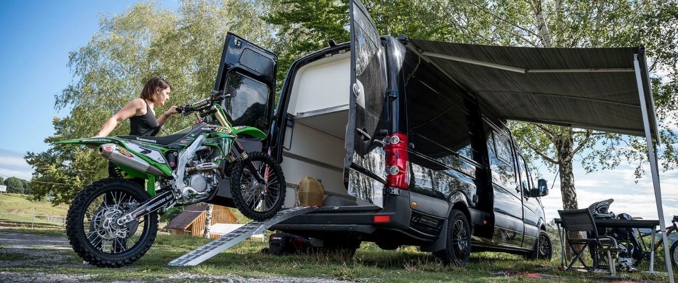 Vanessa lädt ihr Motorrad aus dem Transporter Vanessa lädt ihr Motorrad aus dem Transporter